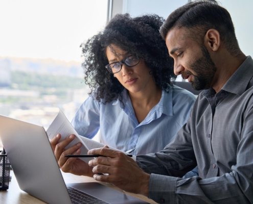 Two Business People Talking At Office Desk