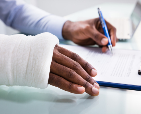 Worker With Arm In Cast Signing Documents