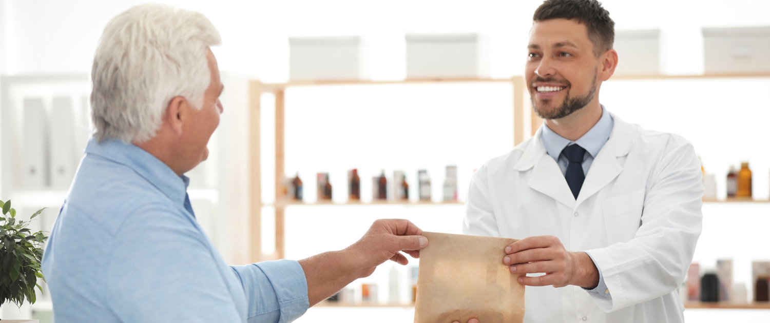 Man At A Dispensary Handing Man Prescription